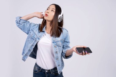 Güzel bir kadın telefonuyla müzik dinliyor..