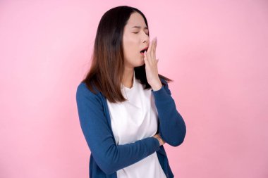 Pembe arka planda esneyen Asyalı kadın.