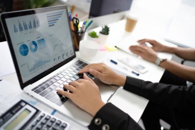 Asyalı bir grup çalışanın elleri çalışma alanında çalışıyor. Dizüstü bilgisayarlarla çalışıyorlar..