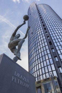 ZAGREB, CROATIA - MAY 09, 2018: Monument of famous Croatian basketball player Drazen Petrovic and Cibona business tower in background