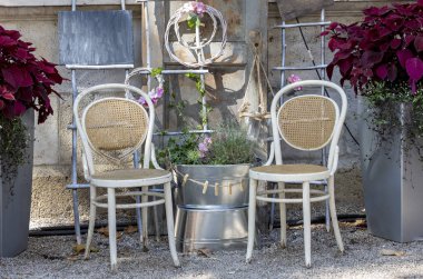 Bahçede iki rustik sandalye çiçeklerle çevrili ve arka planda uzay kara tahta kopyalamak 