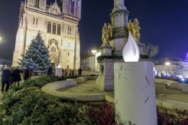 ZAGREB, CROATIA - DECEMBER 27, 2016: Advent in Zagreb, Cathedral and Holiday Tree in front of it, Advent wreath and candle around the fountai