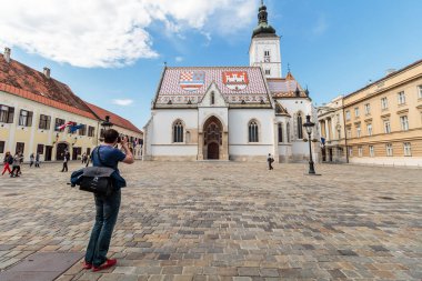 ZAGREB, CROATIA - MAY 07, 2016: Photographer taking picture of St' Mark's square and the Church of St. Mark, Zagreb, Croatia