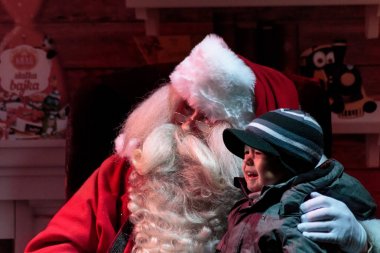 ZAGREB, CROATIA - DECEMBER 27, 2015: Finnish, real Santa Claus Joulupukki from Rovaniemi visiting Advent in Zagreb, child crying in Santa lap. Close up 