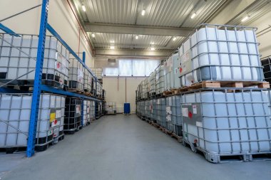 ZAGREB, CROATIA - DECEMBER 21, 2016: Warehouse with chemicals in IBC containers. IBC is used for storage and transport of chemicals. clipart