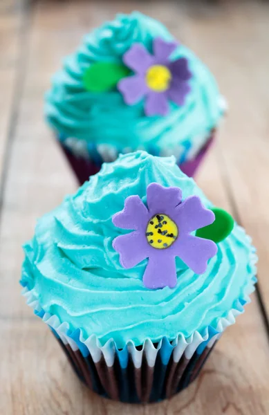 Cupcake with blue icing and purple flower