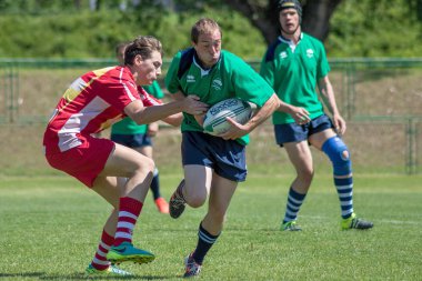 ZAGREB, CROATIA - MAY 6, 2017: Zagreb 7's - Rugby Tournament. Rugby player running and holding ball in hand