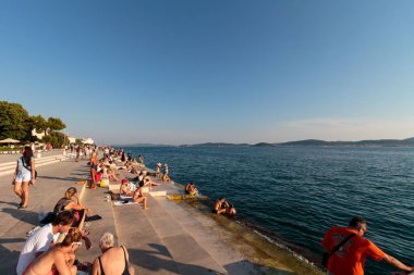 Zadar, Hırvatistan - 10 Temmuz 2016: Zadar famoust Sea Organs 'ta dinlenen insanlar. Deniz orgu 2006 yılında Kentsel Kamu Alanı dalında Avrupa Ödülü kazandı. Boşluğu kopyala