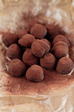Karamelize fındık cipsi ile doldurulmuş çikolatalı trüf mantarı ve kakao tozu