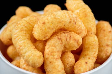 Siyah arka plan üzerinde beyaz kupa içinde atıştırma çevirir