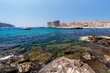 Kristal berraklığındaki denizi ve arka planda Dubrovnik Eski Kenti ile kıyı şeridi