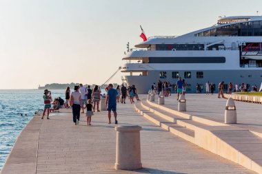 Zadar, Hırvatistan - 10 Temmuz 2016: Zadar famoust Sea Organs 'ta dinlenen insanlar. Deniz orgu 2006 yılında Kentsel Kamu Alanı dalında Avrupa Ödülü kazandı..