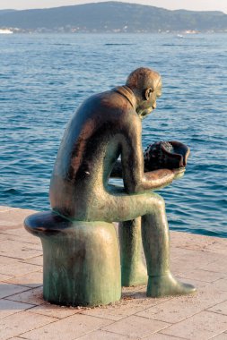 Zadar, Hırvatistan - 10 Temmuz 2016: Deniz kabuğu tutan ve denize bakan bir adamın heykeli