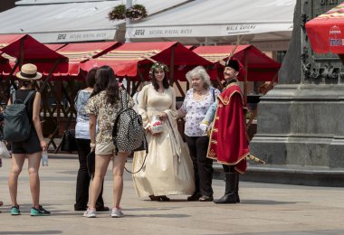 ZAGREB, CROATIA - AUGUST 05, 2015: Tourist taking pictures with entertainers dressed as Manda and ban Jelacic at ban Jelacic square in Zagreb, croatia