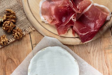 Camembert ve prosciutto eski rustik ahşap masa üzerinde