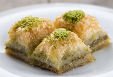 Beyaz tabakta antep fıstığı ve cevizli baklava. Sığ alan derinliği