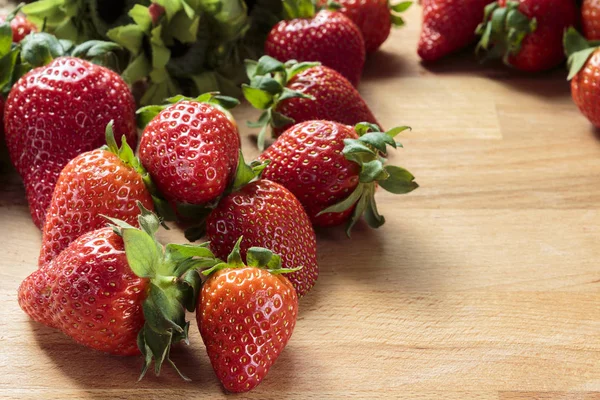 Tahta tahta üzerinde kırmızı çilek yığını 