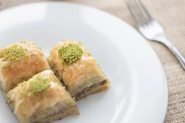 Baklava with pistachios and walnuts on white plate