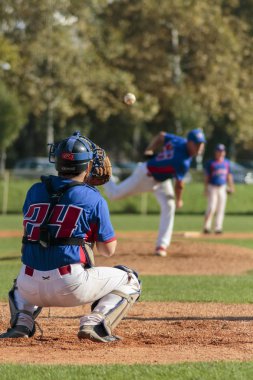 Zagreb. Hırvatistan - 12 Ekim 2014: Beyzbol kulübü Zagreb 'de mavi forma, Olimpija' da ise koyu mavi forma giydi. Tanımlanamayan beyzbol tutucusu ve atıcı birbirlerine pas veriyorlar.