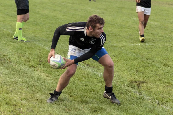 ZAGREB, CROATIA - SEPTEMBER 13, 2014: ZAGREB, CROATIA - SEPTEMBER 13, 2014: Rugby match Rugby Club Zagreb in white jersey and Rugby Club Sinj in black jersey. Unidentified player passing the ball.