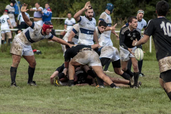 ZAGREB, CROATIA - SEPTEMBER 13, 2014: Rugby match Rugby Club Zagreb in white jersey and Rugby Club Sinj in black jersey. Unidentified player's tackle each other and passing ball
