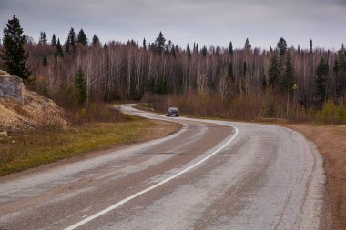 Virajlı asfalt yolundaki araba.