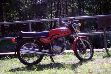 Kırmızı Honda Twin Cb 125 motosiklet alanlarda bir köprü üzerinde