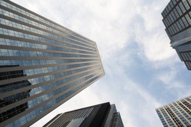 Tall modern skyscrapers viewed from street level against blue sky