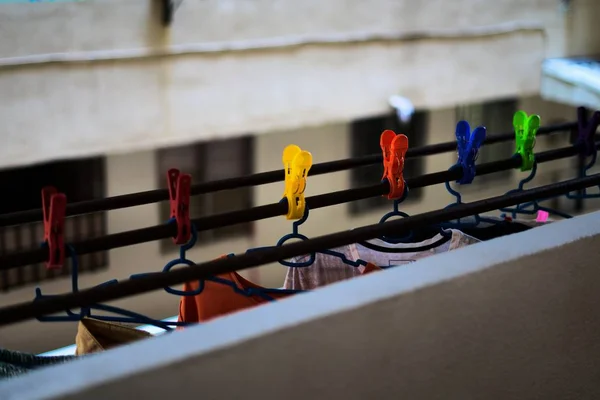 Farvet clothespin holder hængende tøj i en højhus blok - Stock-foto