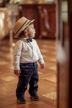 Şapkalı mutlu çocuk keyifle izliyor.