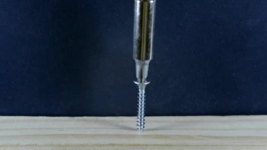 Tornavida vidayı tahtaya saplar. Delgiyle vidayı tahtaya saplar..