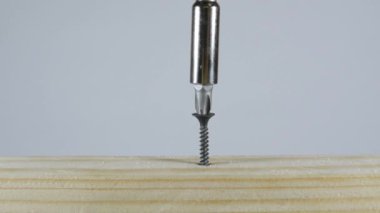 Tornavida vidayı tahtaya saplar. Delgiyle vidayı tahtaya saplar..