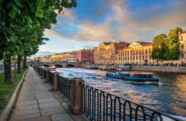 Nehir tekne turları St Petersburg Fontanka Nehri üzerinde bir güneşli yaz akşam ve uzaktan Anichkov Köprüsü