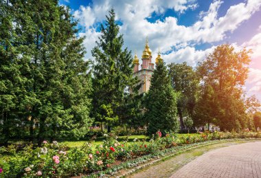 Gatehouse Predtechensky Kilisesi, Lavra Sergiev Posad içinde yeşil ağaçların arasında altın kubbeleri
