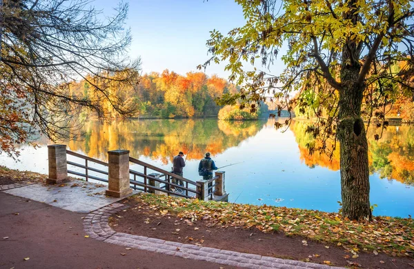 漁師はモスクワのツァリツィノ公園の池の岸に魚をキャッチし 水に反射して多色の美しい黄金と赤の木 — ストック写真