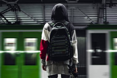 Siyah sırt çantası olan bir tren istasyonunda durdurulan bir adam