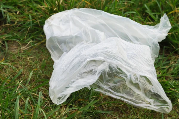 Plastic pollution - polythene is lying down in the grass — Stock Photo, Image