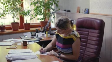 Ofisteki kız patron belgeyi imzalıyor.