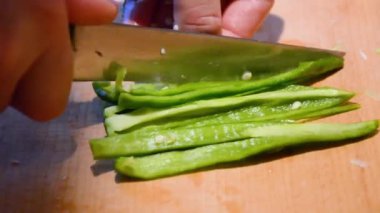 Tahta bir tahta üzerine biber dilimleme.