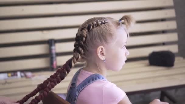 ピグテールは若い女の子に編み込まれた 美容院でヘアスタイルをやってるあなたの髪のスタイル — ストック動画