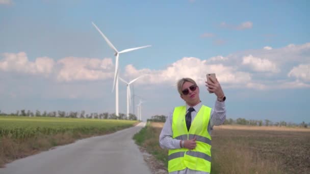 Vrouwelijke Ingenieur Een Oranje Vest Stropdas Regelt Werking Van Windgeneratoren — Stockvideo