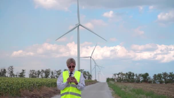 Vrouwelijke Ingenieur Een Oranje Vest Stropdas Regelt Werking Van Windgeneratoren — Stockvideo