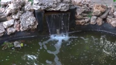 Dinlenmek için yeşil bir parkta küçük çeşme ve şelale