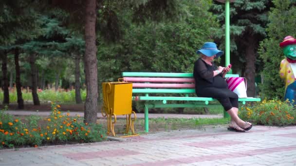 Una Donna Anziana Sta Riposando Parco Siede Una Panchina Guarda — Video Stock