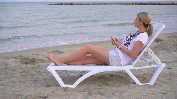 Meisje rustend op een ligstoel aan zee — Stockfoto