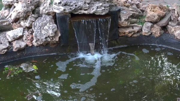 Kleiner Brunnen und Wasserfall in einem grünen Park zur Entspannung — Stockfoto