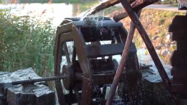 La pression de l'eau fait tourner un vieux moulin à eau. Pulvérisation volant dans différentes directions 