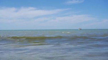 Güneşin altında parlayan dalgalar kıyıya ulaşıyor..