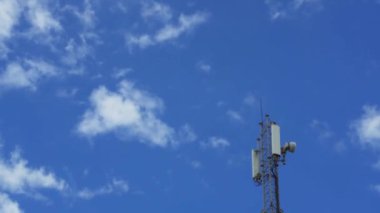 Yüzen bulutların arka planına karşı bir baz istasyonu. Bir cep telefonu operatörünün iletişim ekipmanları. Mobil ağ kapsamı.