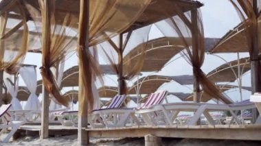 Otel tatili için boş salonlar. Rüzgâr perdeleri sallıyor. Güneşten korunmak için. Deniz kıyısındaki spa tedavileri. Rahatlamak için bir yer..